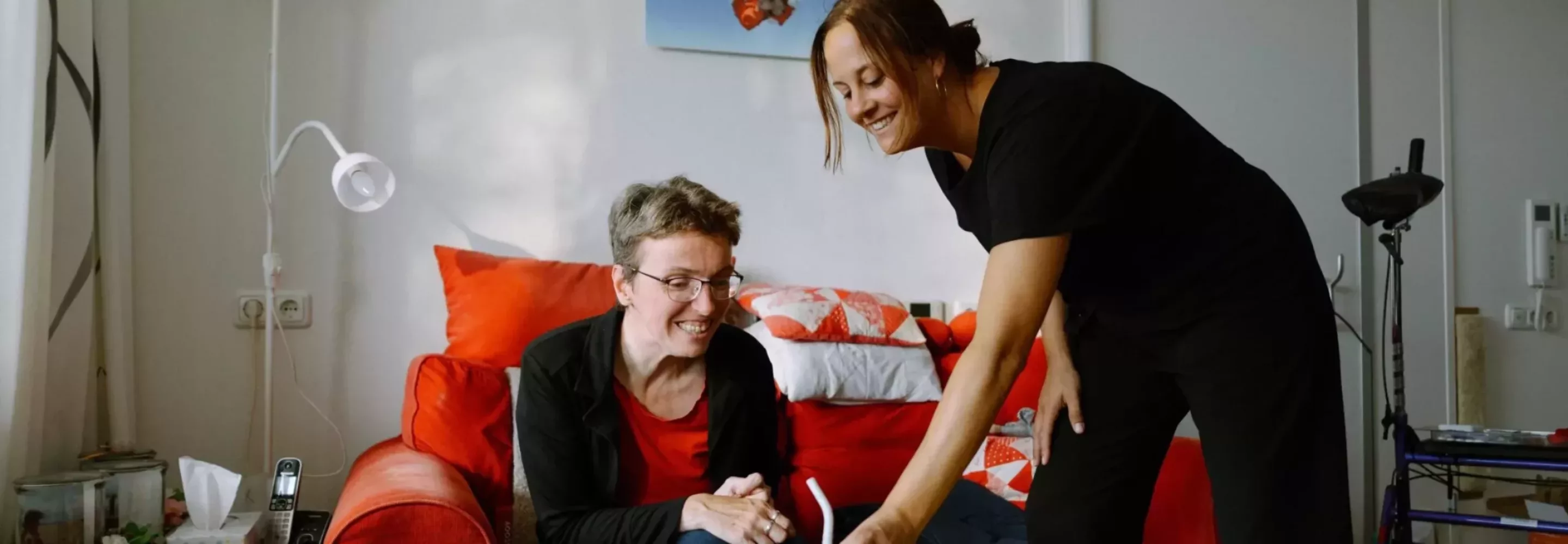 Zorgmedewerker helpt een vrouw in een rolstoel tijdens werken in de zorg in Drenthe.